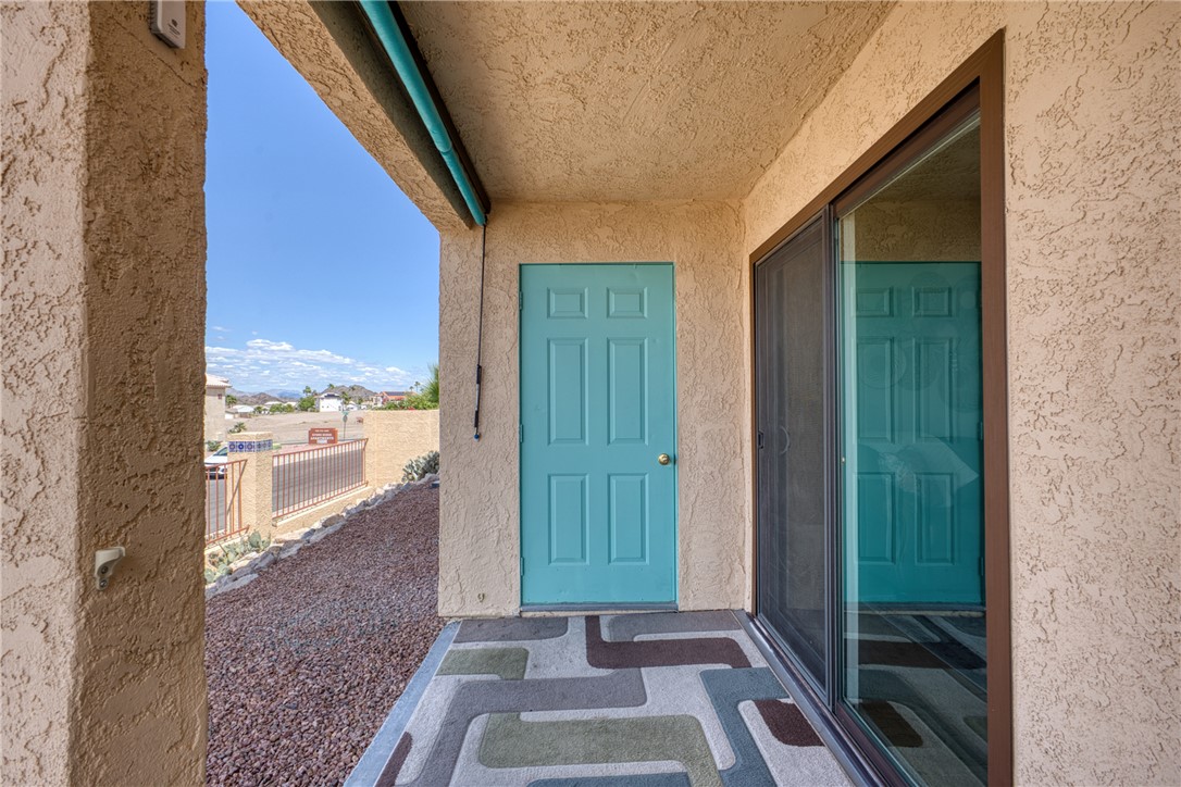 3400 Sunriver Road, Unit D2 Bullhead City, AZ 86429 - Photo 43 of 61 The property features a patio area with a light blue exterior door and a sliding glass door