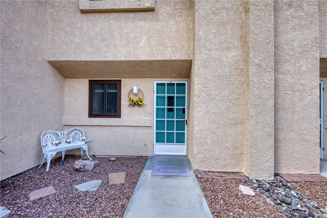 3400 Sunriver Road, Unit D2 Bullhead City, AZ 86429 - Photo 3 of 61 The property features a textured stucco exterior, a front entry with a security screen door, and a paved walkway