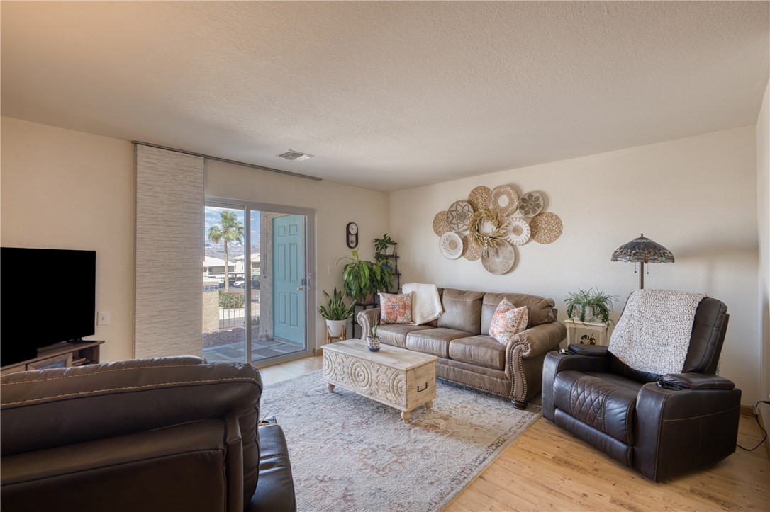 3400 Sunriver Road, Unit D2 Bullhead City, AZ 86429 - Photo 4 of 61 The property features a bright living area with a sliding glass door providing access to the outdoors, and light-colored flooring