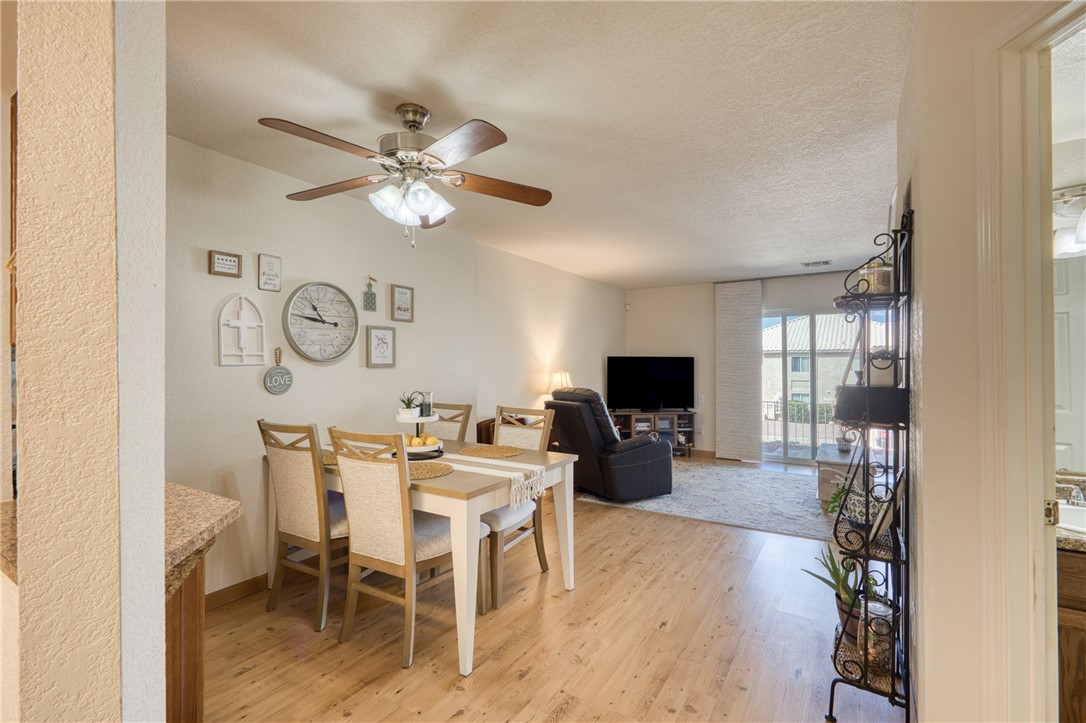 3400 Sunriver Road, Unit D2 Bullhead City, AZ 86429 - Photo 7 of 61 This property features light wood flooring, a dining area with a ceiling fan, and a living area with sliding glass doors