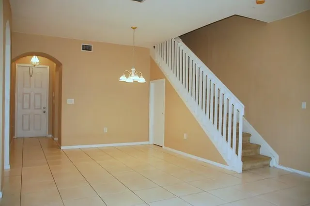 a view of a hallway with entryway wooden floor and stairs