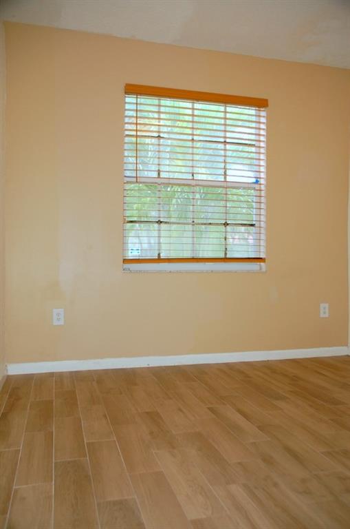 18713 Southwest 26th Street Miramar, FL 33029 - Photo 7 of 32 a view of an empty room with wooden floor and a window