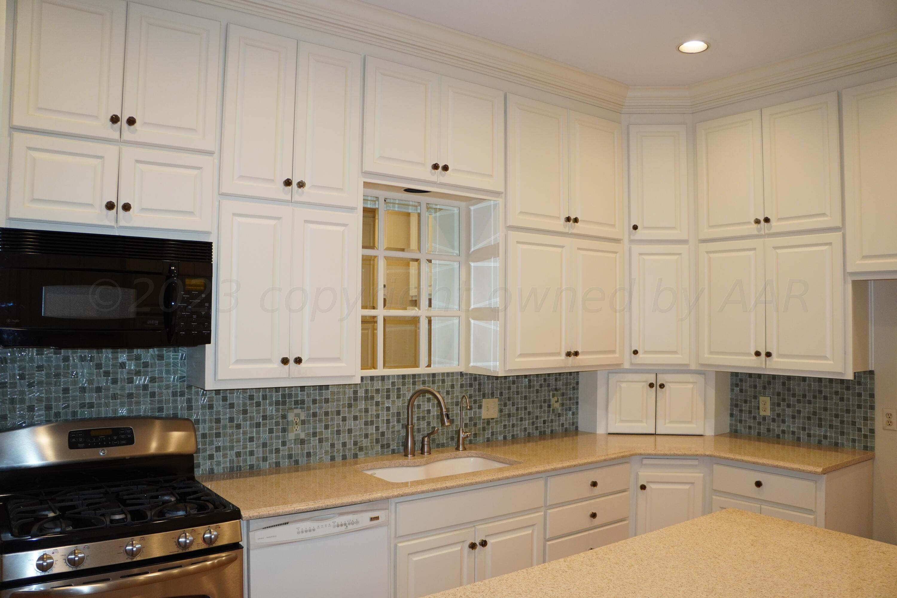 22 Edgewater Drive Amarillo, TX 79106 - Photo 17 of 52 a kitchen with white cabinets and appliances