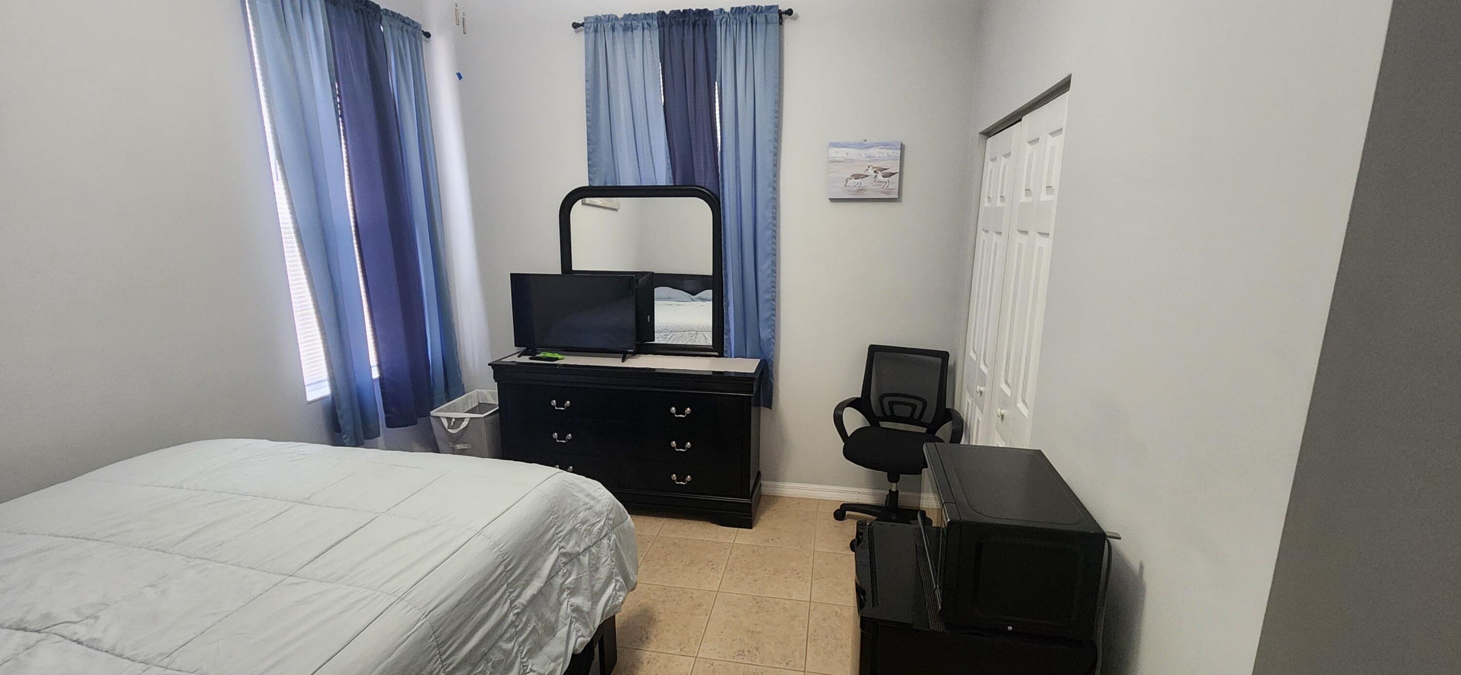315 Kaye Street Fort Pierce, FL 34947 - Photo 57 of 66 a bedroom with a bed and a flat tv screen on dresser