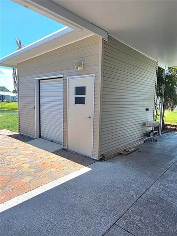 a view of a swimming pool with a lawn chairs under an umbrella