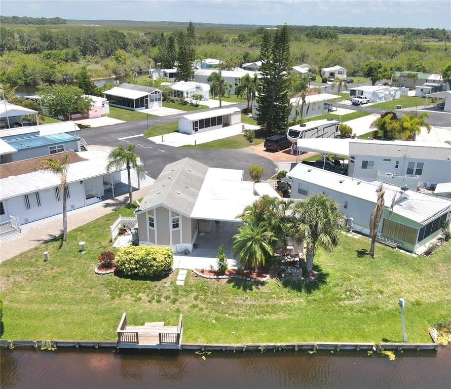 14280 Northeast 124th Avenue, Unit 242 Okeechobee, FL 34974 - Photo 14 of 19 a view of a swimming pool with a lawn chairs under an umbrella