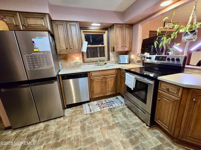 a kitchen with stainless steel appliances granite countertop a sink stove and refrigerator