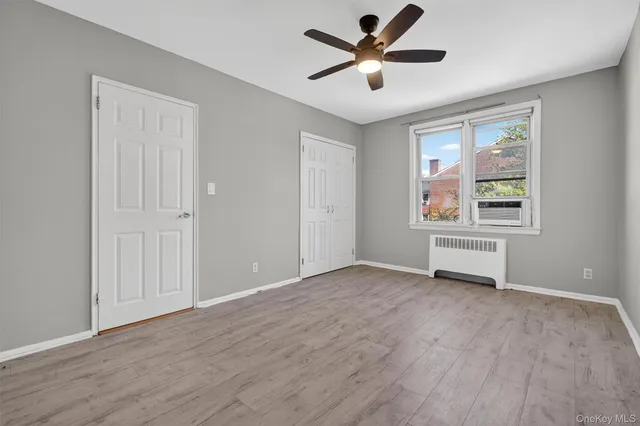 an empty room with windows and a ceiling fan