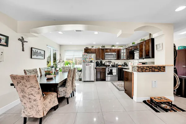 a kitchen with stainless steel appliances kitchen island granite countertop a refrigerator and a stove top oven