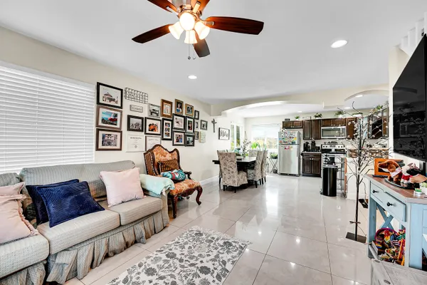 a living room with furniture kitchen view and a window