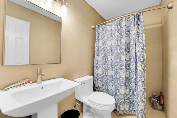 a bathroom with a sink a toilet and shower curtain