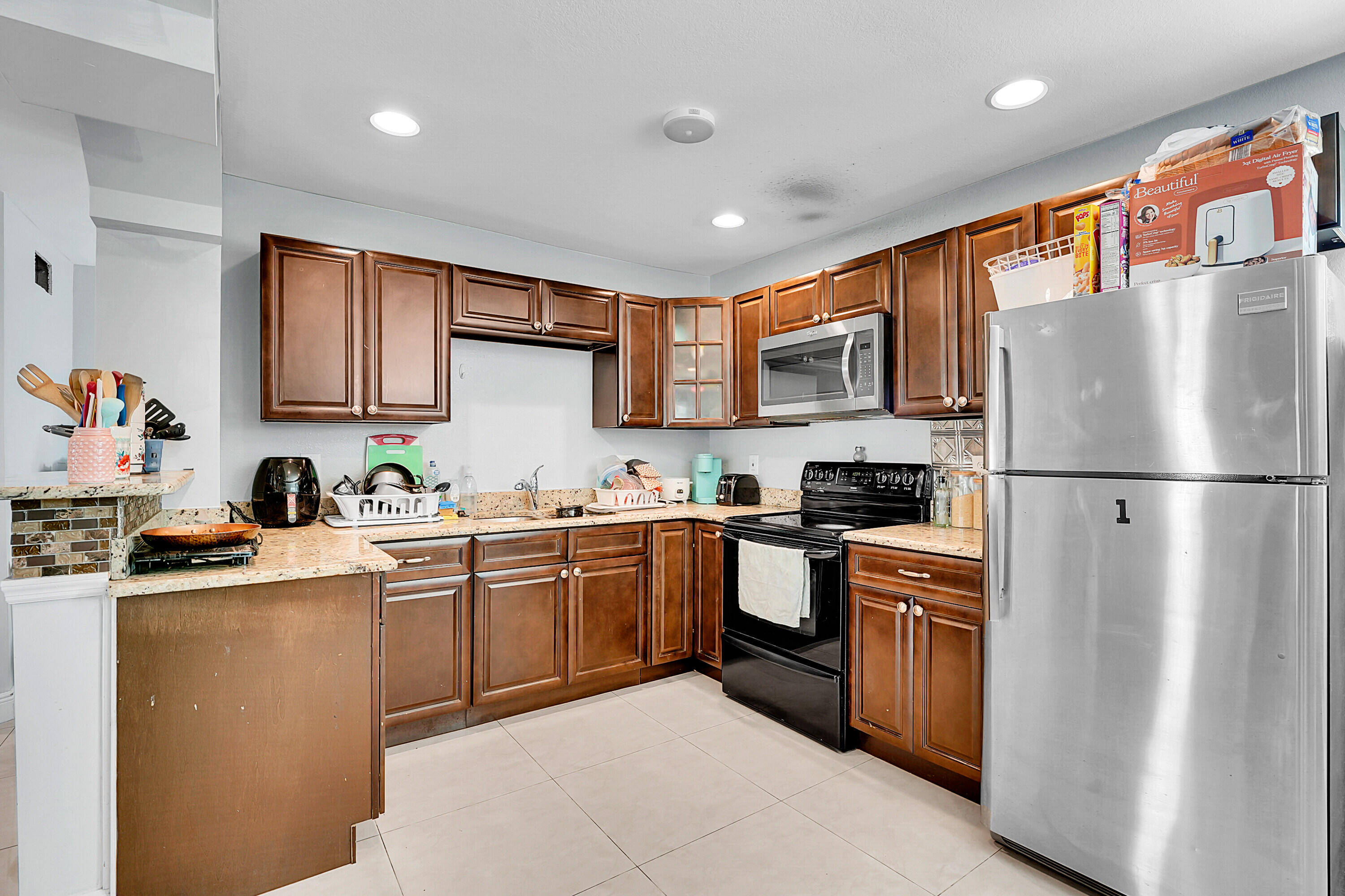 2856 Harson Way Fort Pierce, FL 34946 - Photo 30 of 37 a kitchen with stainless steel appliances granite countertop a refrigerator sink and stove