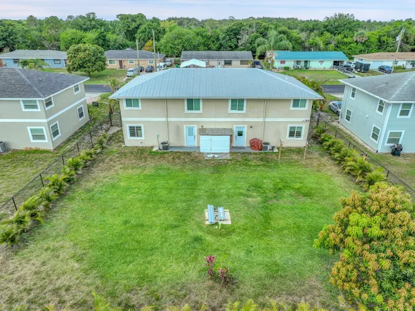 a aerial view of a house with table and chairs under an umbrella