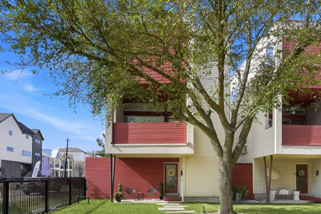a view of a cafe with table and chairs and a large tree