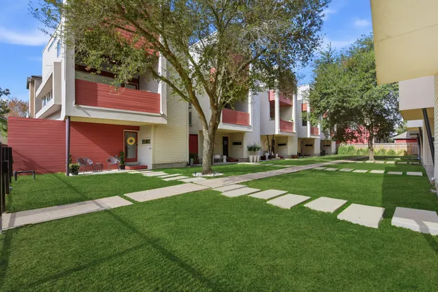 a front view of a house with a yard and tree