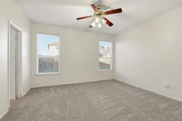 an empty room with a window and a ceiling fan