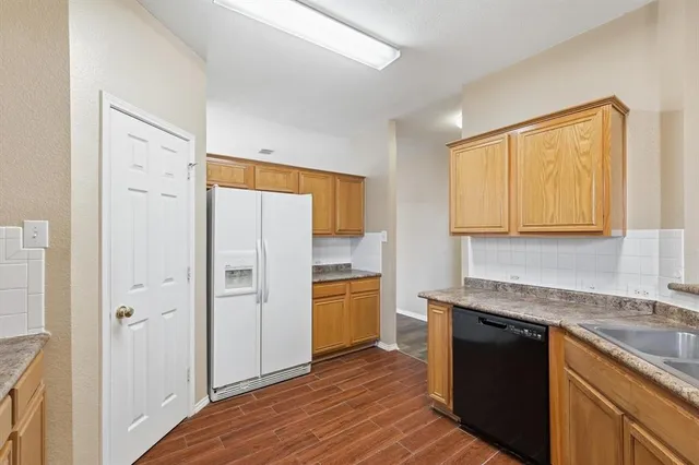 a kitchen with a refrigerator sink and cabinets
