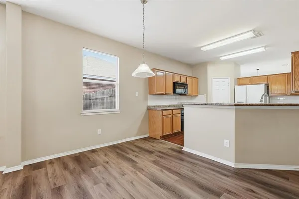 a kitchen with granite countertop a stove a sink and a microwave