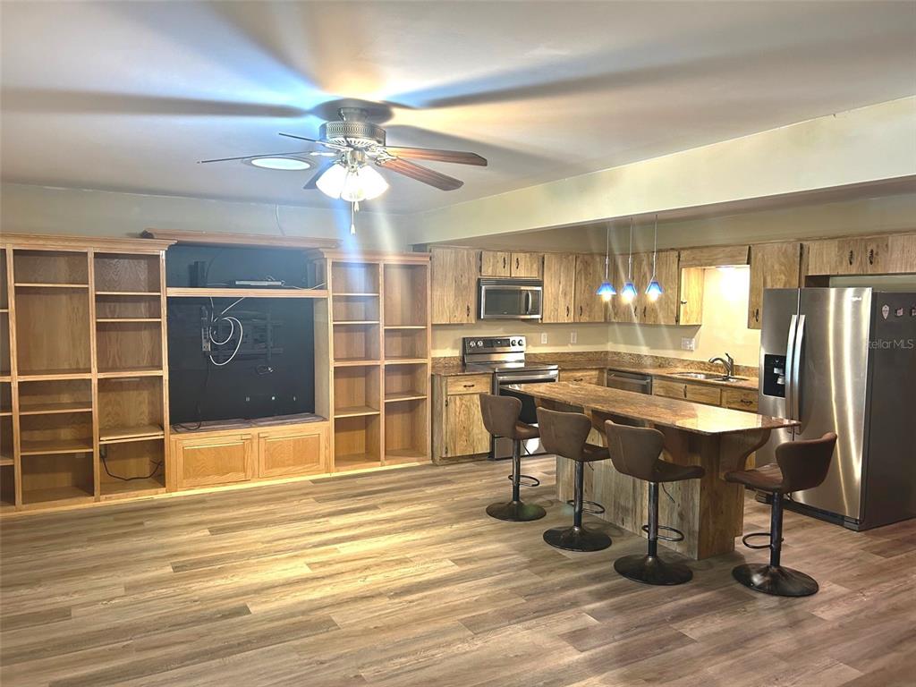 8655 Southwest 98th Street Road, Unit A Ocala, FL 34481 - Photo 12 of 24 Large Family room with Custom Built Entertainment center, Kitchen with updated countertop and Island.