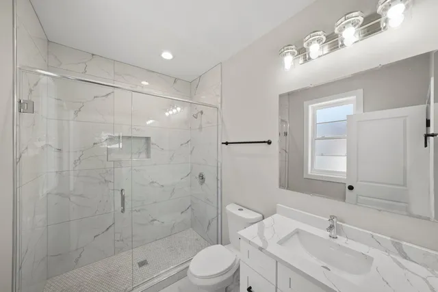 a bathroom with a sink a toilet and shower