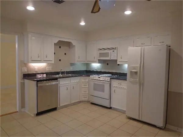 a kitchen with granite countertop cabinets and steel stainless steel appliances