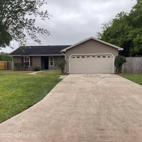 a view of a house with a yard and large tree