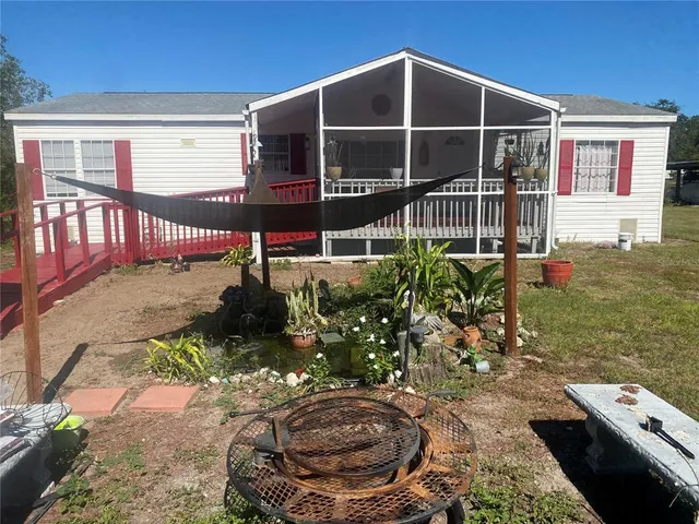 a view of a house with large windows and wooden fence