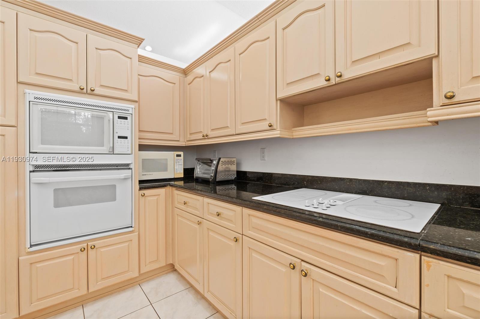 12982 Southwest 27th Street Miami, FL 33175 - Photo 13 of 43 a kitchen with white cabinets and white appliances