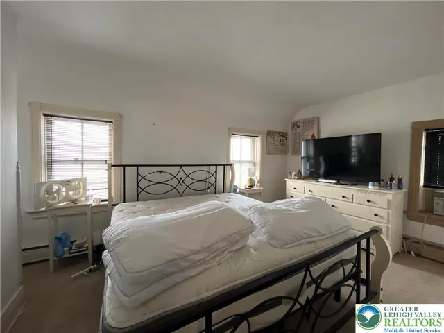 a bedroom with a bed and a flat screen tv