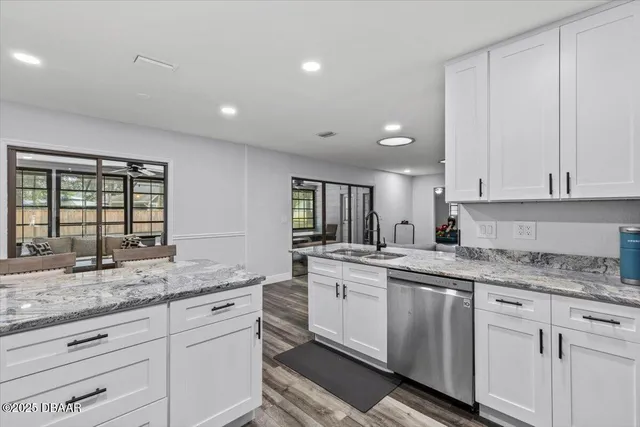 a kitchen with granite countertop white cabinets and white stainless steel appliances
