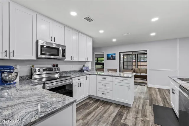 a kitchen with stainless steel appliances granite countertop a stove a sink and a microwave