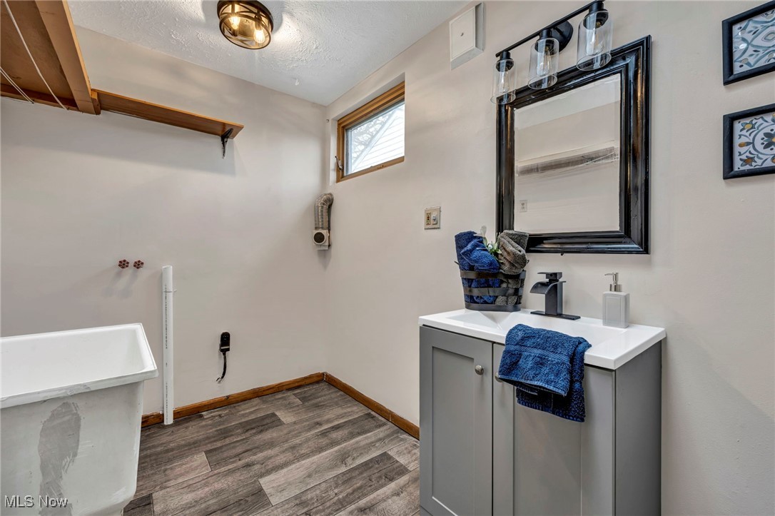 6030 Dunham Road Maple Heights, OH 44137 - Photo 37 of 50 Bathroom featuring vanity, dark wood finished floors, and a textured ceiling