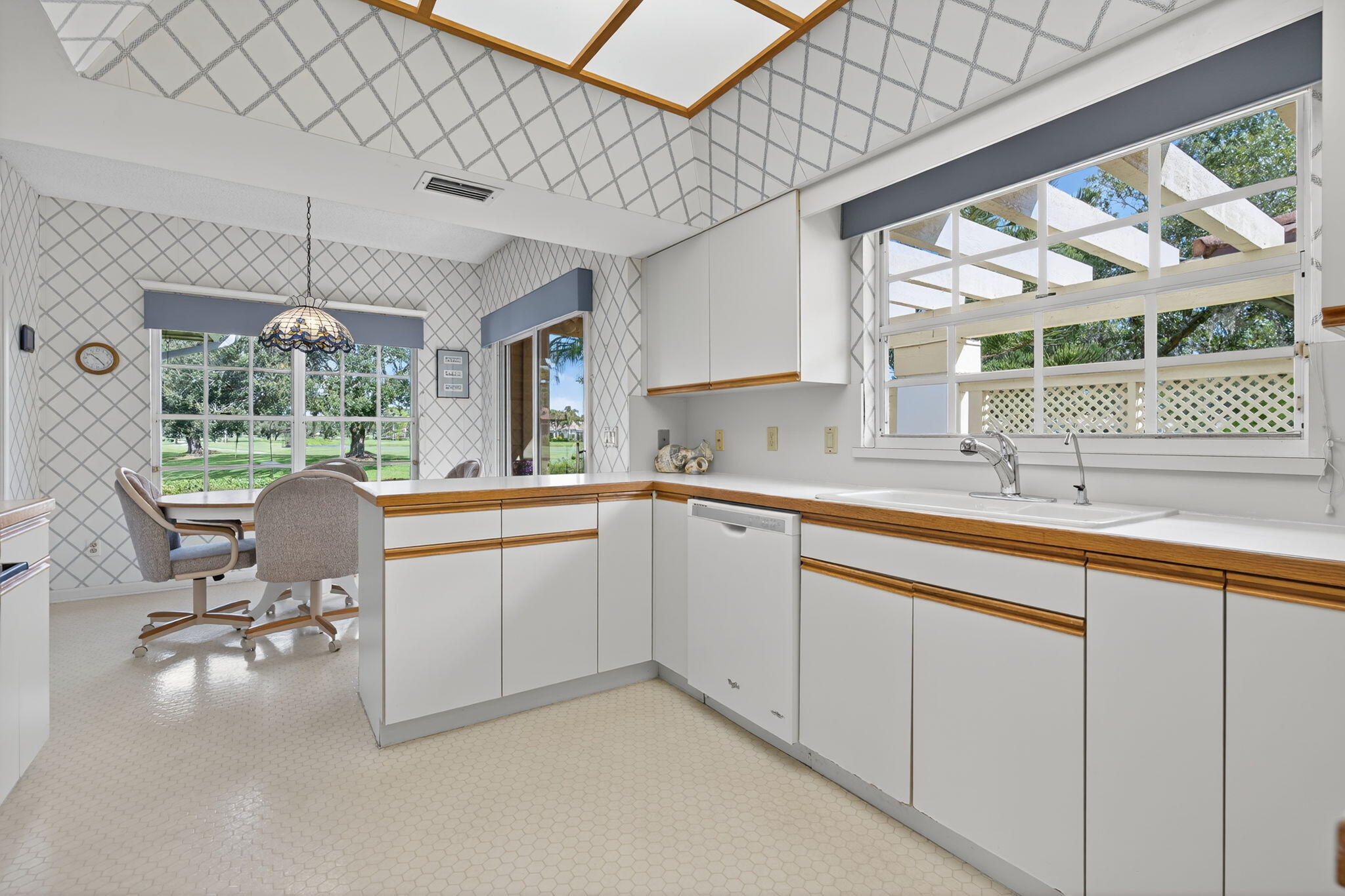 7036 Southeast Winged Foot Drive Stuart, FL 34997 - Photo 23 of 65 a kitchen with table and chairs next to a yard