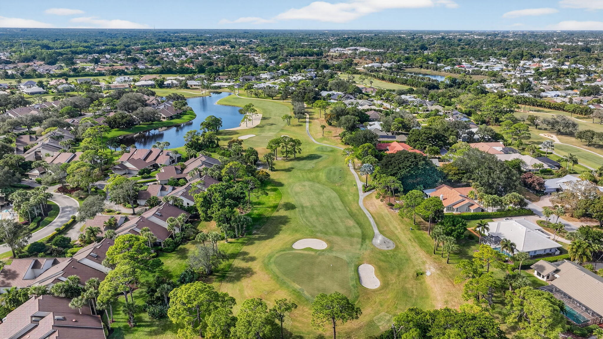 7036 Southeast Winged Foot Drive Stuart, FL 34997 - Photo 63 of 65 an aerial view of residential houses with outdoor space and trees