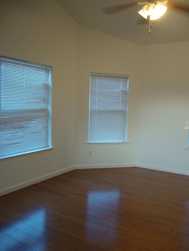 142 East Shoemake Avenue Reedley, CA 93654 - Photo 9 of 10 a view of an empty room with wooden floor and a window