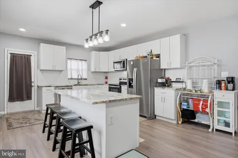 a kitchen with stainless steel appliances a stove refrigerator sink and microwave