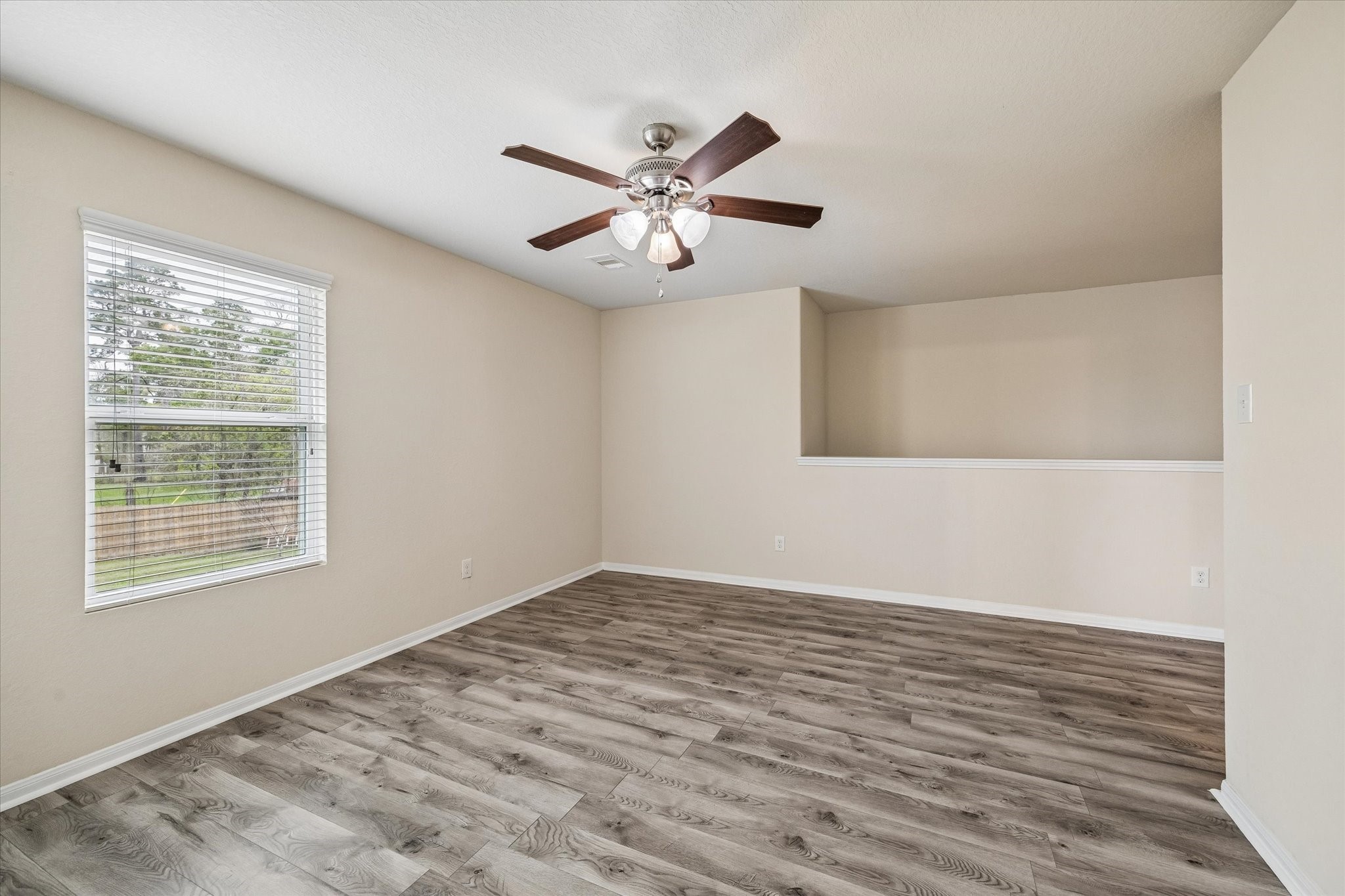 15642 South Fall Fern Circle Houston, TX 77044 - Photo 24 of 32 a view of an empty room with window and wooden floor