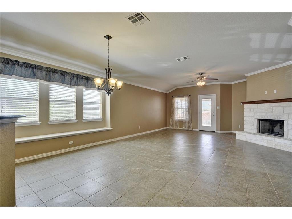 2109 Granite Springs Road Leander, TX 78641 - Photo 4 of 30 A comfortable living space featuring a stone fireplace and tiled flooring.