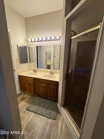a bathroom with a double vanity sink a mirror and a bathtub