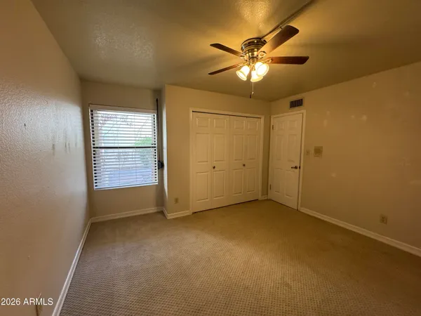 an empty room with closet and windows