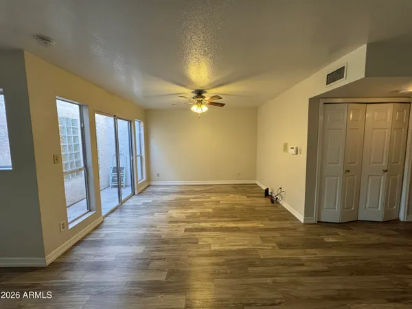 a view of an empty room with wooden floor and a window
