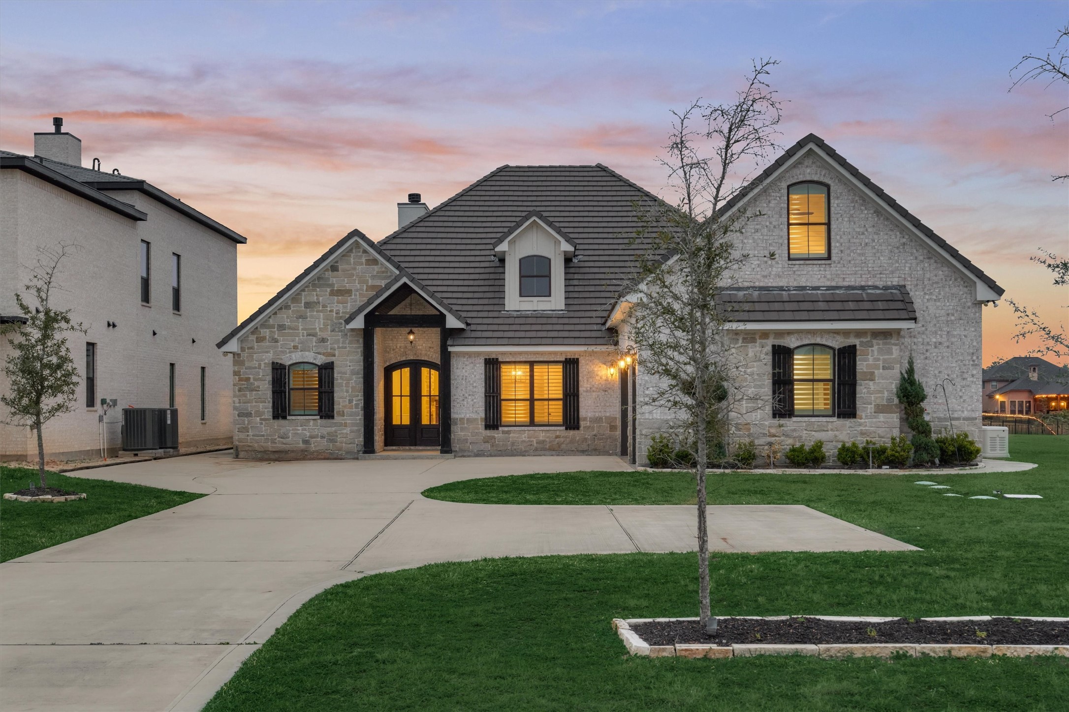 11618 Renaissance Drive Montgomery, TX 77356 - Photo 2 of 47 The stunning front elevation showcases a beautiful blend of brick and stone, complemented by warm wood accents that add depth, texture, and timeless curb appeal.