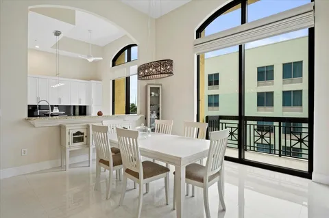 a kitchen with a dining table chairs and white cabinets