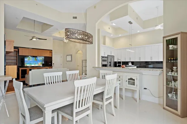 a living room with stainless steel appliances kitchen island granite countertop furniture and a flat screen tv