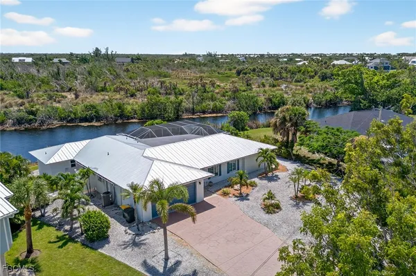 an aerial view of a house with swimming pool and outdoor seating