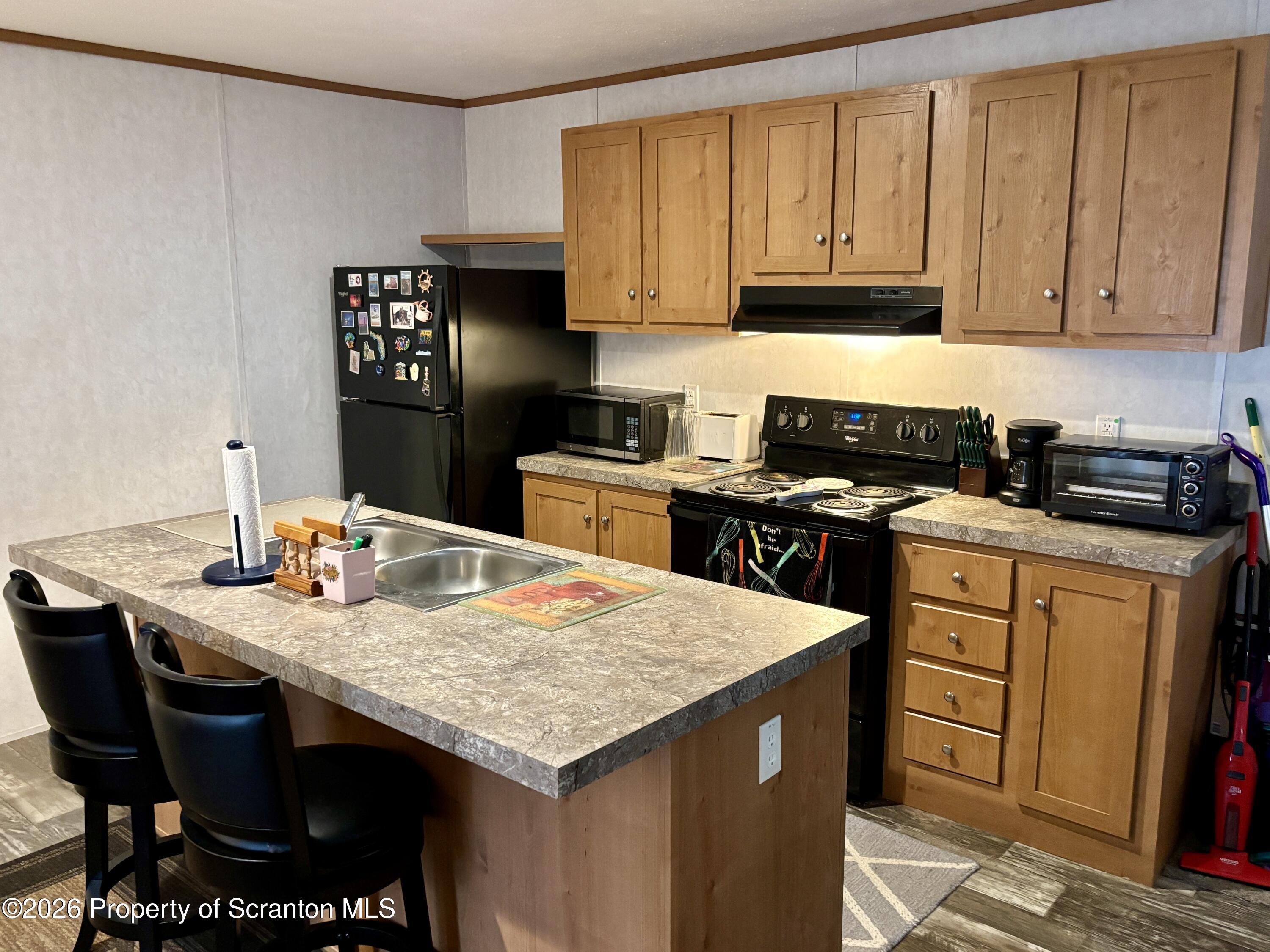 62 Timber Trail Factoryville, PA 18419 - Photo 13 of 23 a kitchen with granite countertop a sink a stove and wooden cabinets