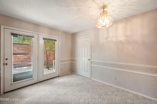 a view of a dining room with furniture a kitchen and chandelier
