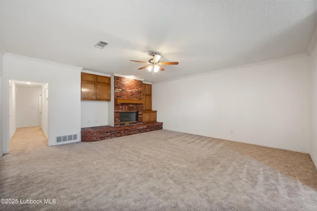en empty room with windows and fireplace