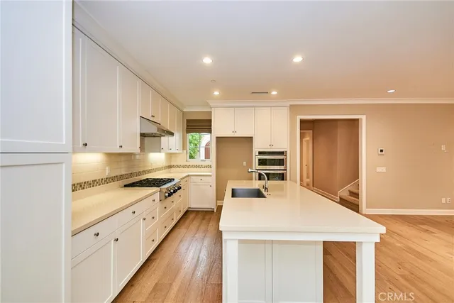 a kitchen with stainless steel appliances kitchen island granite countertop a stove a sink and a refrigerator