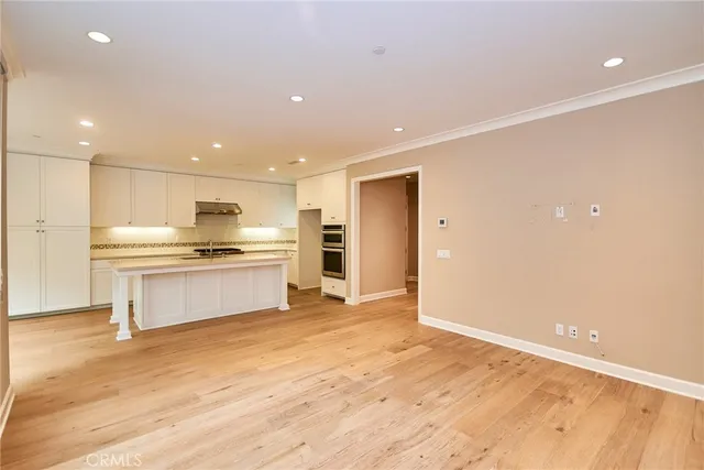 a kitchen with granite countertop a stove and a white cabinets
